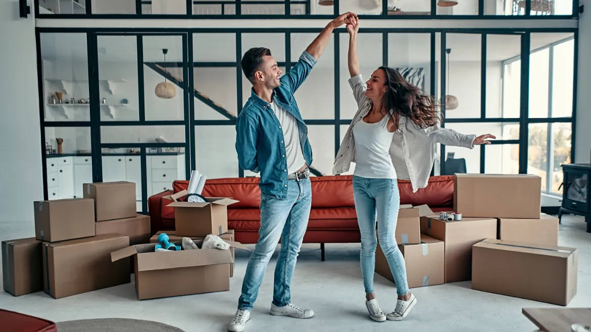 Happy couple dancing near moving boxes, TrekMovers