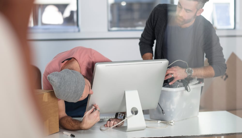 Men carefully packing a computer monitor for moving, TrekMovers