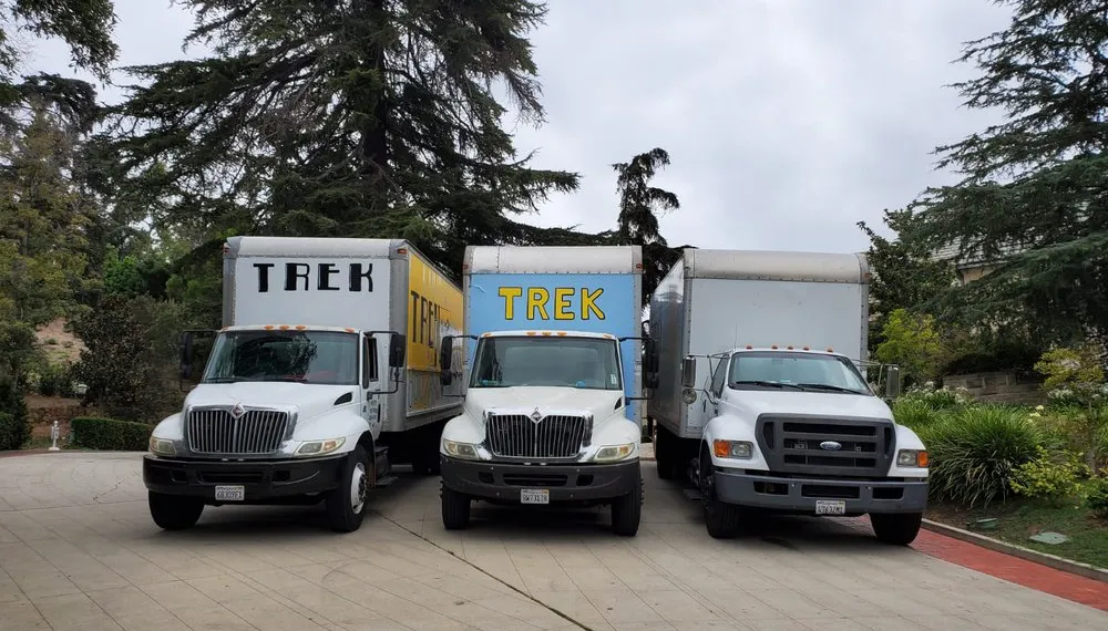 Three moving trucks parked side by side, TrekMovers