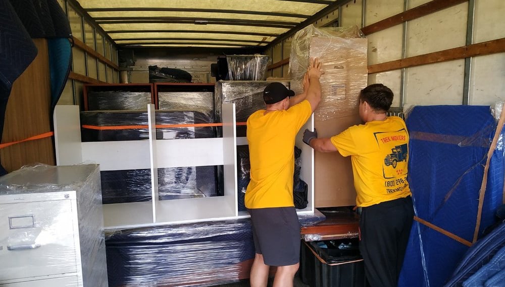 Men loading a moving truck with furniture and boxes, TrekMovers
