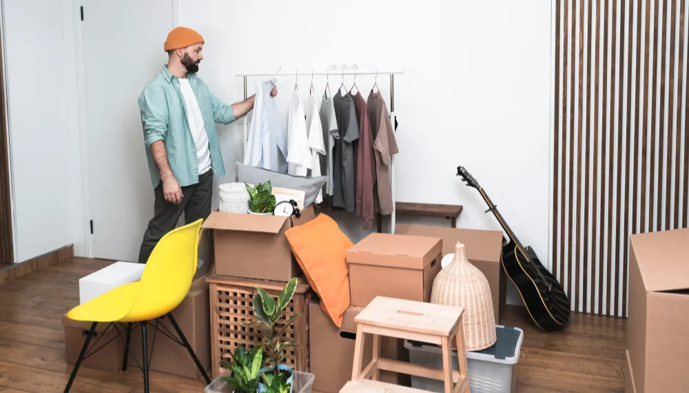 Man folding clothes while preparing for a move, TrekMovers