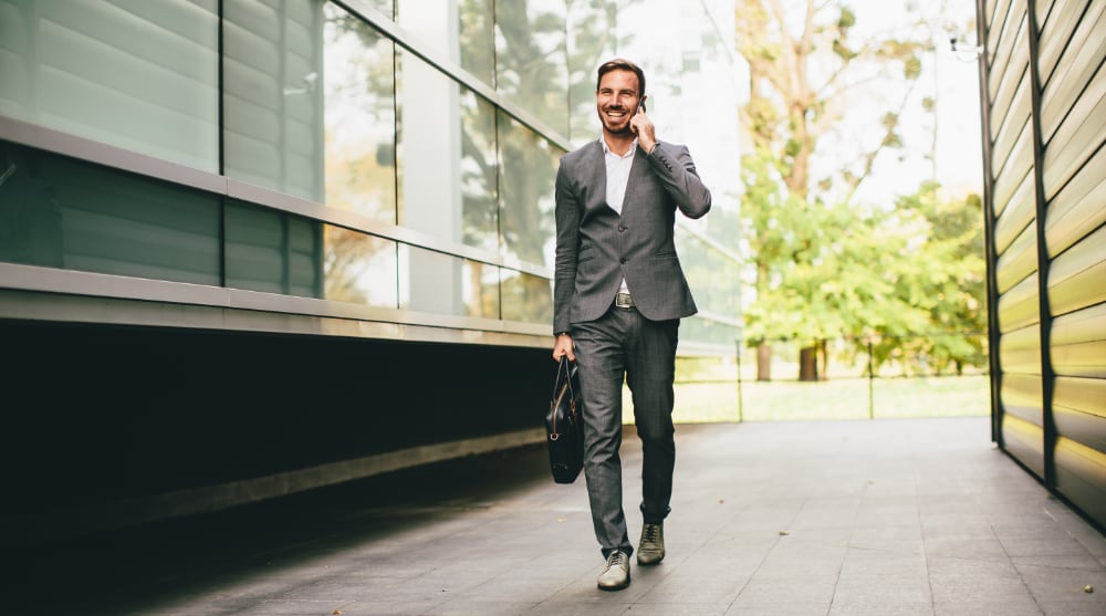 Man walking down a city street on a sunny day, TrekMovers