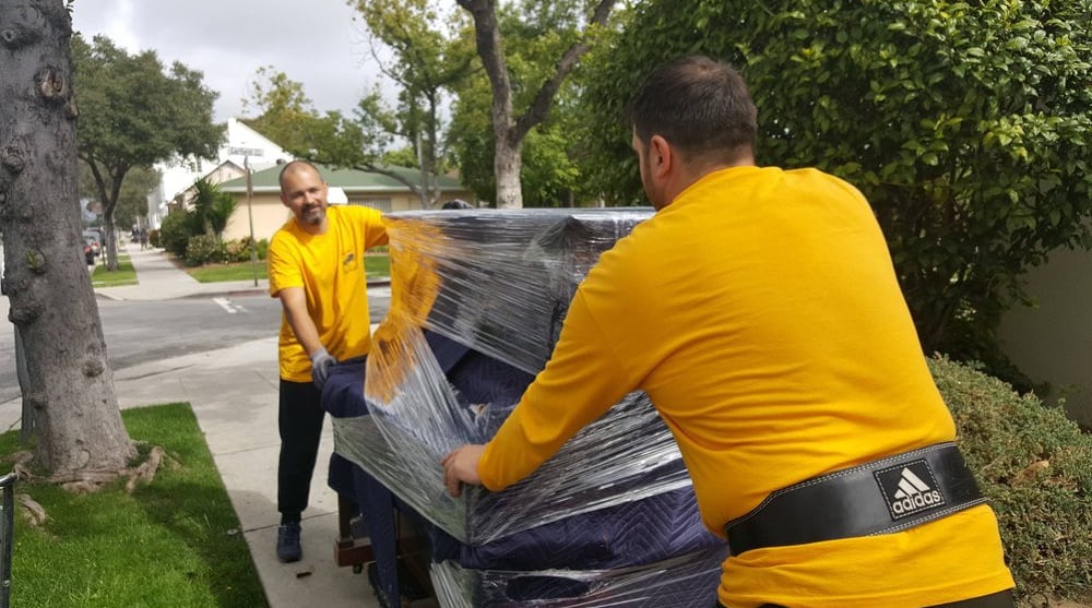 Two men carrying furniture during a home move, TrekMovers