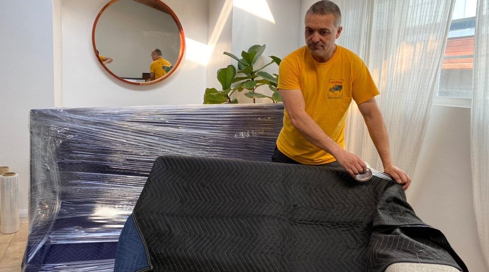 Person packing fragile items carefully with bubble wrap, TrekMovers